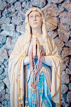Marienfigur mit Rosenkränzen